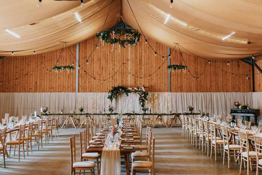 Wedding meal set up with long tables, fairy lights and flowers